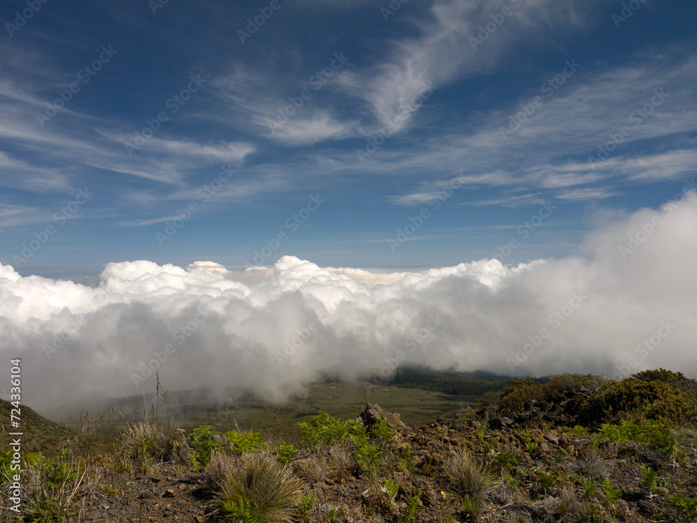 Standing on the higher ground above the clouds concept, view from the Top of Haleakala volcano with beautiful mountain valley on Maui Hawaii Standing on the higher ground above the clouds concept, view from the Top of Haleakala volcano with beautiful mountain valley on Maui Hawaii