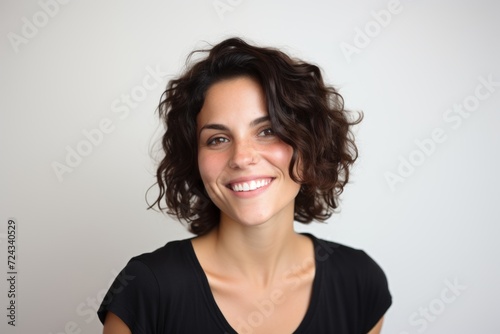 Portrait of a beautiful young woman with curly hair smiling at the camera