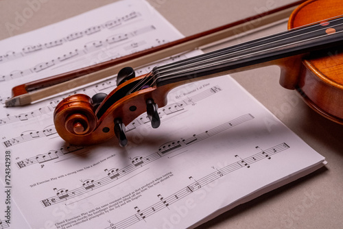 Geige mit Bogen und Notenheft vor einfarbigem Hintergrund, Studioaufnahme, Deutschland