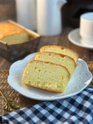 Slices of butter cakes with small white tea set. 