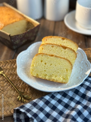 Slices of butter cakes with small white tea set. 