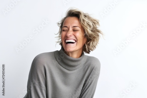 Portrait of a young woman laughing against a white background with copy space