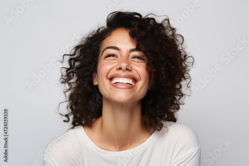 Portrait of a young beautiful woman with curly hair, laughing.