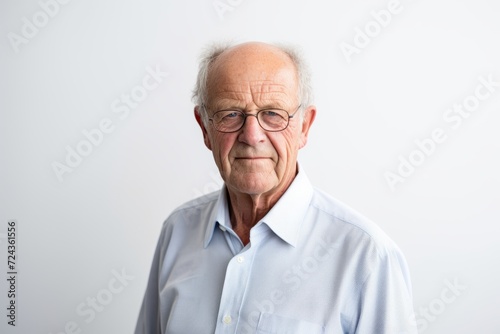 Portrait of a senior man with glasses on a white background. © Iigo