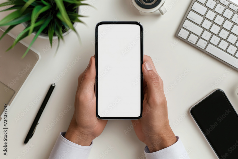Cropped shot of businessman using smartphone with blank screen while sitting at modern office desk Cropped shot of businessman using smartphone with blank screen while sitting at modern office desk