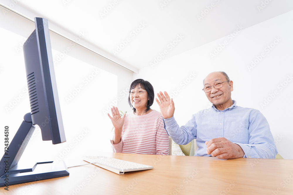 Fototapeta premium パソコンでテレビ電話をする高齢の夫婦