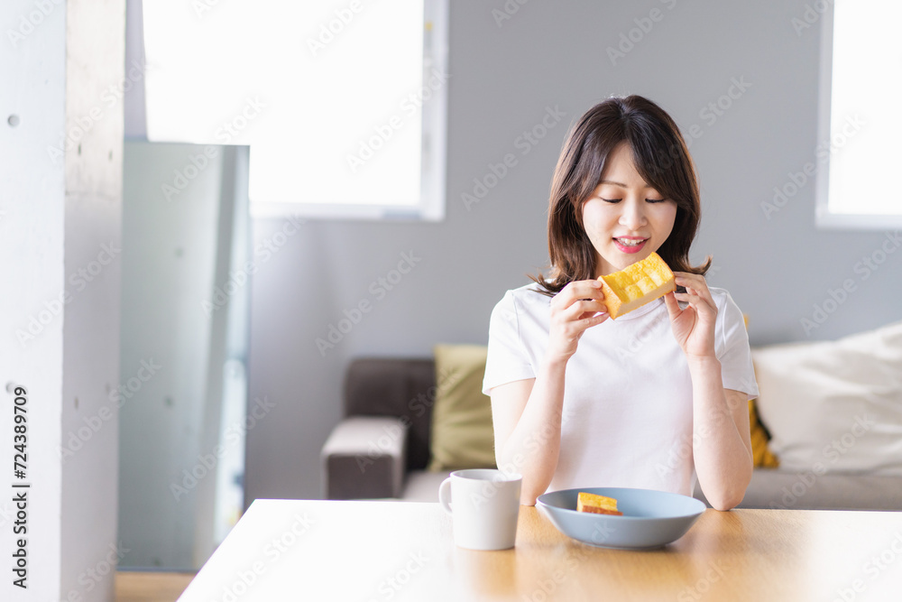 自宅で朝食を食べる若い女性