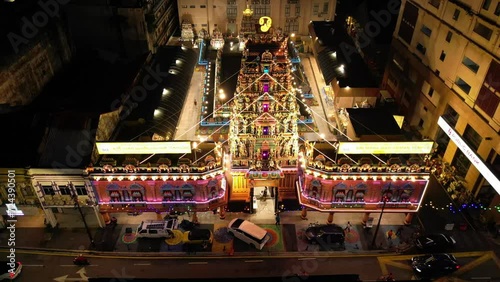 KL Mahamariamman Hindu Temple night light. Smooth aerial top view flight drone photo