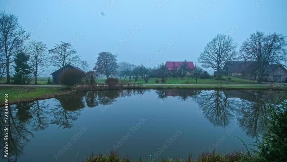 Night to day timelapse of foggy pond with homes looking out over water Night to day timelapse of foggy pond with homes looking out over water