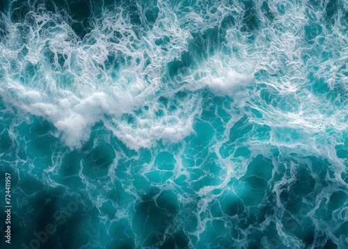 an aerial view of ocean water with swirling white foam patterns over a deep turquoise sea