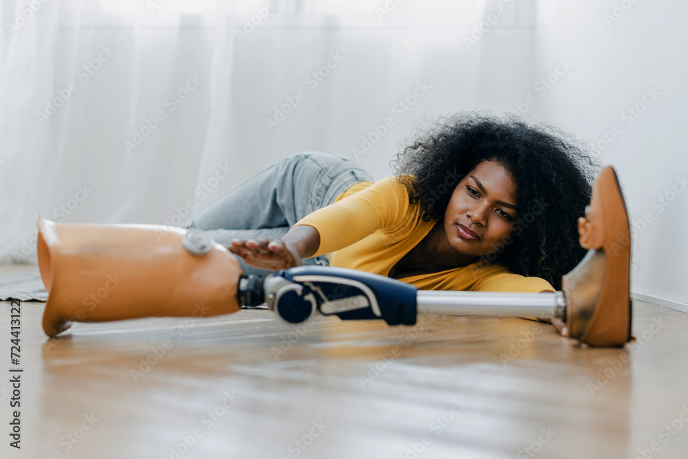Woman with trying catch prosthetic leg on floor in bedroom. People with ...