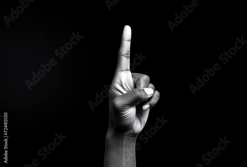 Hand pointing up on a black background. Black and white photo.