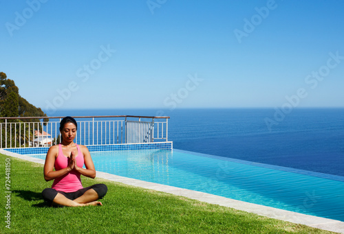 Meditation, yoga and woman on grass by pool for holistic fitness, mindfulness and breathing exercise. Summer, hands in prayer and person by ocean for wellness, health and zen energy outdoors