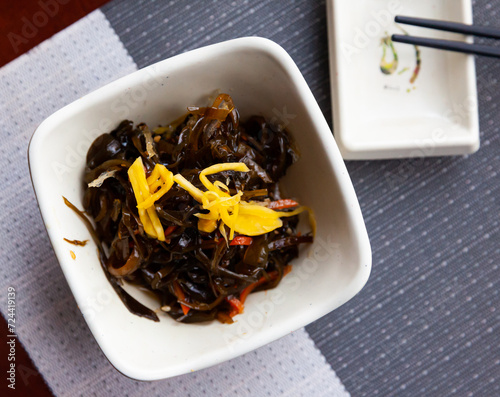 Seaweed salad with sauce and sesame in white bowl, japanese cuisine