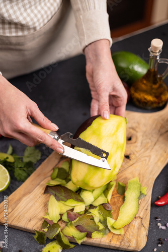 Cooking mango salsa - woman peeling mango fruit