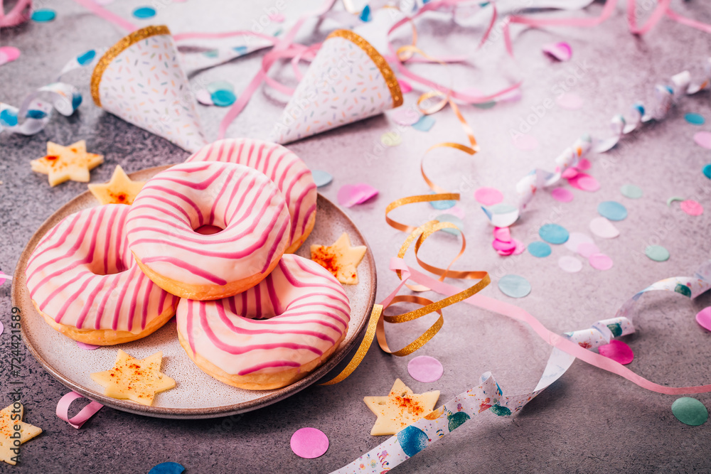 Donuts for carnival and party. German Krapfen or donuts with streamers and confetti. Donuts for carnival and party. German Krapfen or donuts with streamers and confetti.