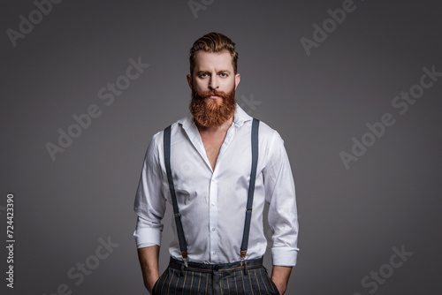 Retro man in suspenders isolated on grey. Mature redhead man with hairstyle. Vintage male fashion style. Male vintage style. Vintage brutality guy in retro suspenders