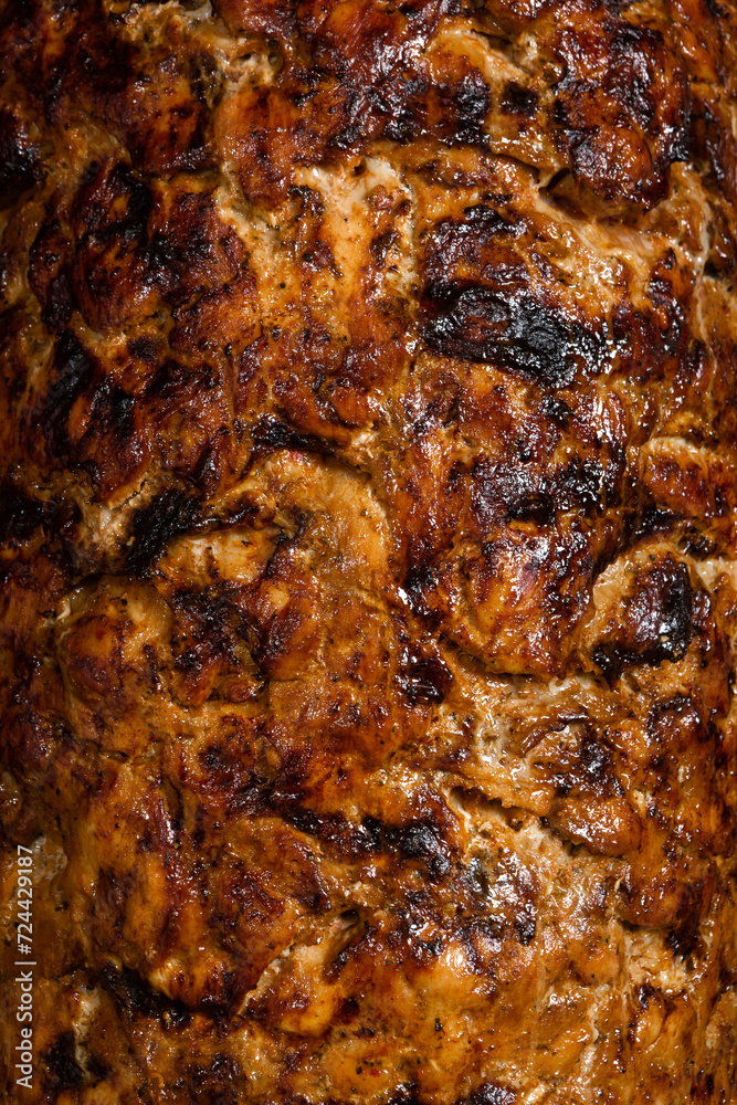 Closeup of kebab meat cooking in a souvlaki shop.