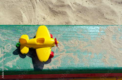 Yellow airplane toy on a wooden playground