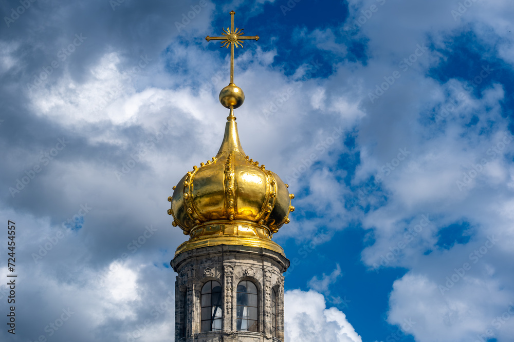 The gilded dome of the church against the blue sky.