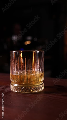 whiskey pours into a glass the bartender's hand pours alcohol from a jigger into a glass 