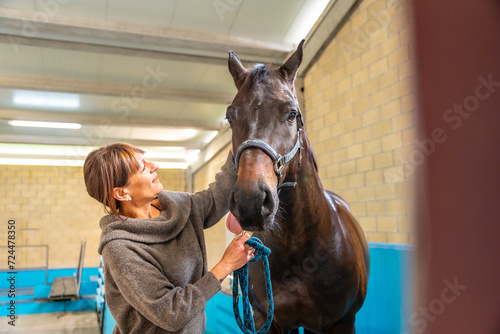 Veterinary caressing a horse after hydrotherapy on a center photo
