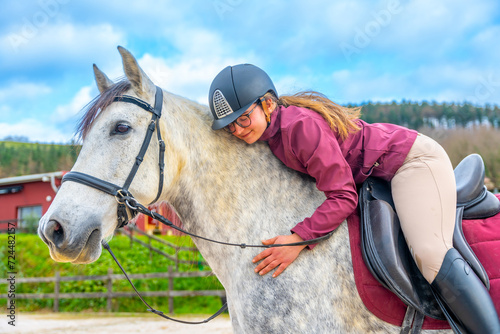 Woman embracing a horse while riding it
