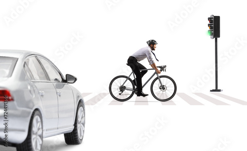 Profile shot of a businessman riding a bicycle with a helmet in fromt of a car at pedestrian crossing