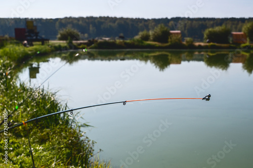 A rod and reel in the background of the lake. Fishing, recreation, hobby. Copy space