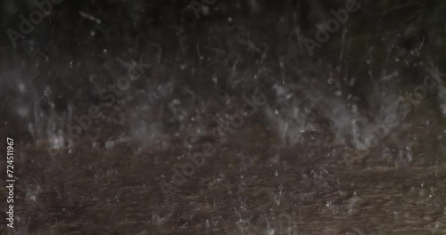 Water hitting a concrete sidewalk during a heavy rain storm photo