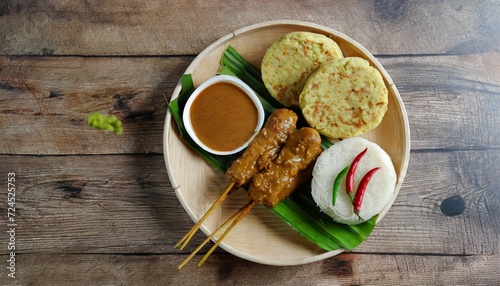 sate kere popular street food in solo surakarta central java topped with peanut sauce and accompanied with rice cake shallots and chili pepper photo