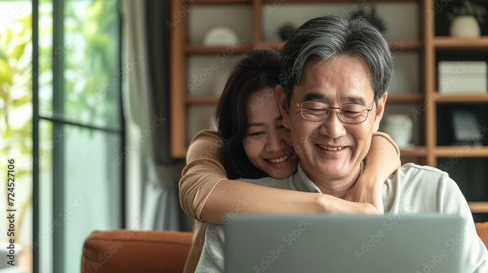 Couple using laptop, hugging and smile. 