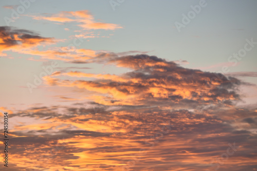 A beautiful sky tinted by the sun leaving vibrant shades of gold, pink, blue and multicolored. Clouds in the twilight evening and morning sky. Cloudy sky background in the evening and during the day.