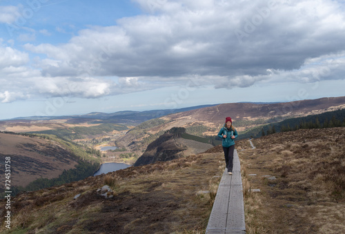 free and happy mountaineer woman walks on wooden walkway in national park wicklow mountains ireland