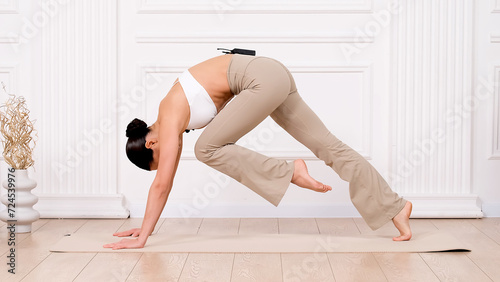 Fitness woman doing exercise for all muscle groups. An active girl is doing a workout on a light background. The concept of a healthy, beautiful female body.