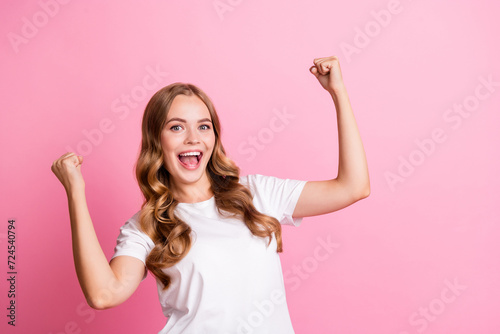 Portrait of young awesome gorgeous model raised fists up winning scream and promoting noname brand sale isolated on pink color background photo
