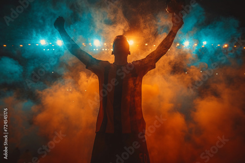 Football champion Silhouette of a man with raised hands in the smoke.