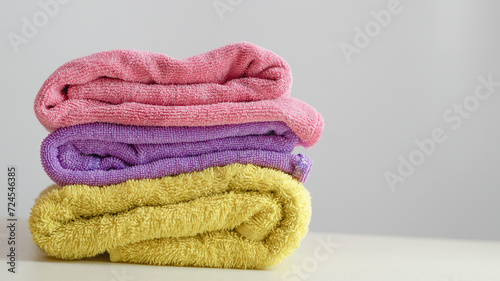 a pile of clean, folded and colored towels on a white background
