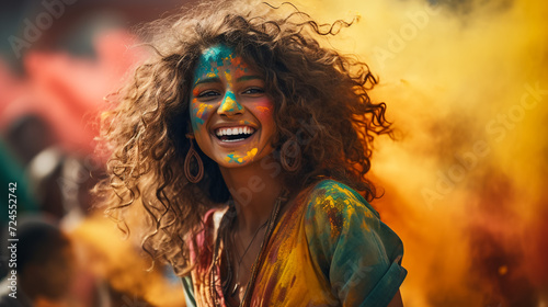 Portrait of happy Indian woman celebrating Holi with powder colours or gulal. Concept of Indian festival Holi. © Mujahid