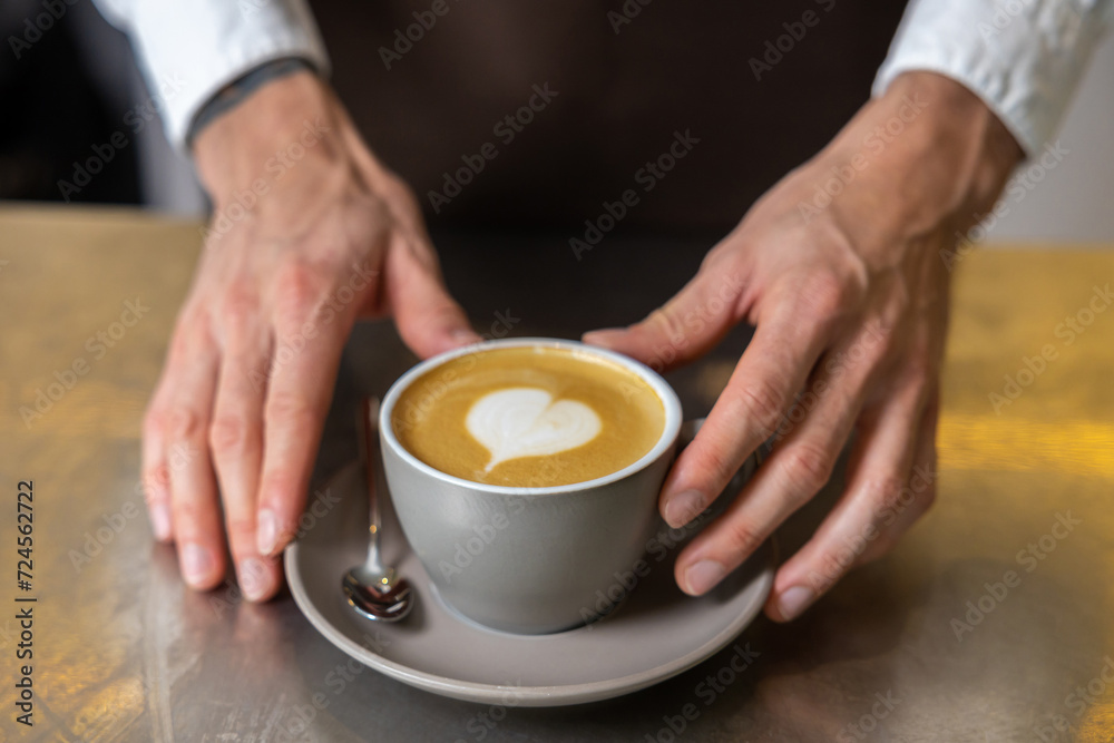 Picture of mans hands putting cup of coffee on the table Picture of mans hands putting cup of coffee on the table