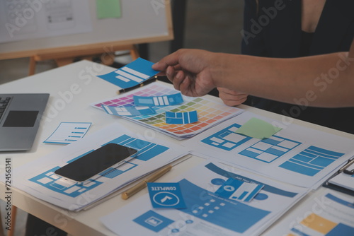 Close up ux developer and ui designer use augmented reality brainstorming about mobile app interface wireframe design on desk at modern office.Creative digital development agency