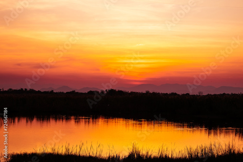 Landscape twilight on evening view sunset over lake with silhouette background. Beauty and nature relaxing scene.