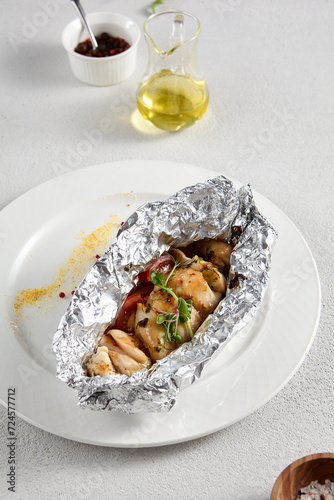 Baked fish in foil with sweet and sour sauce and fresh herbs, perfect for healthy dining and seafood recipes