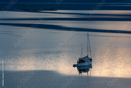 Silhouette of a sailing boat at sunset in Loch Carron, North West Highlands, Scotland, UK © Delphotostock