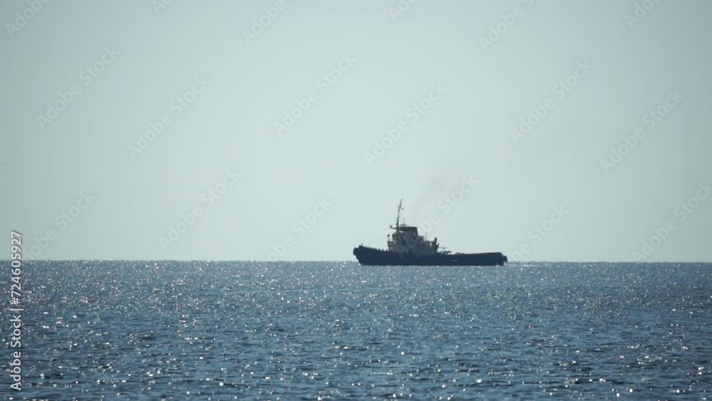 Tug boat in open calm sea, heading back to port at sunset, helps large container ships maneuver. Aerial view, maritime industry, oceanic transportation or business concepts. Tug boat in open calm sea, heading back to port at sunset, helps large container ships maneuver. Aerial view, maritime industry, oceanic transportation or business concepts.
