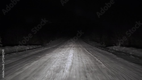 Driving on snow road in forest at night. POV photo