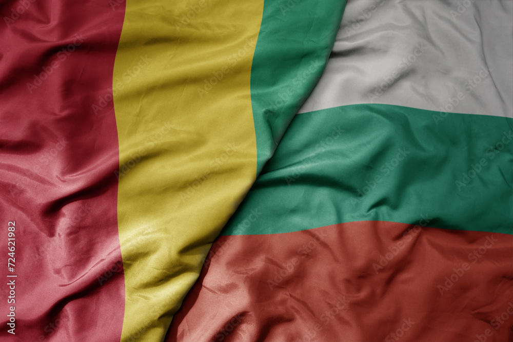 big waving national colorful flag of bulgaria and national flag of guinea .