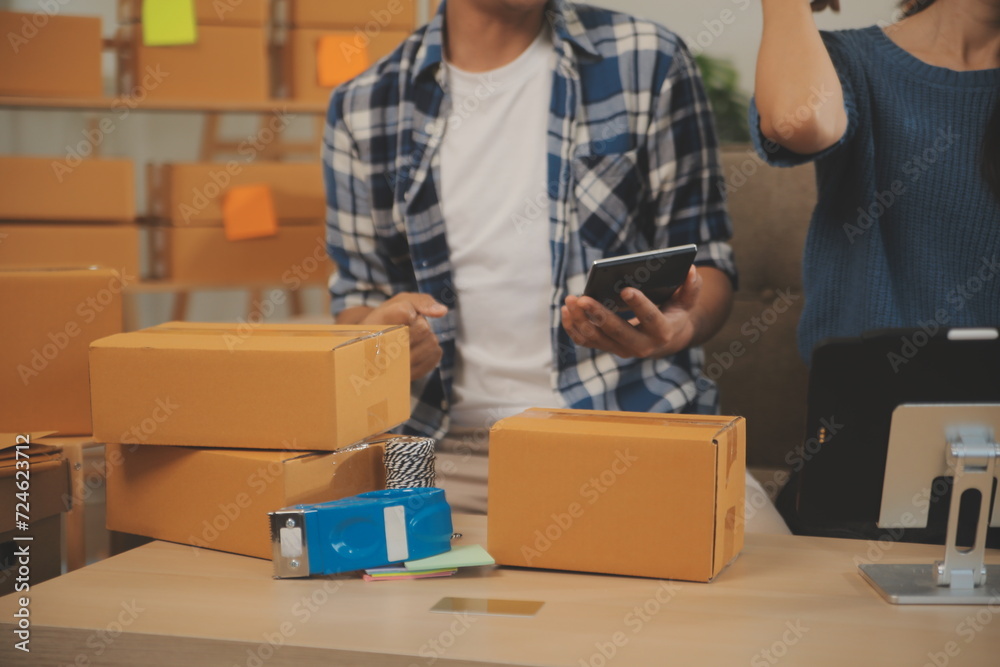 Two Asian blogger showing clothes in front of the camera to recording vlog video live streaming at her shop. Online Shopping Cart notion. on sofa at home