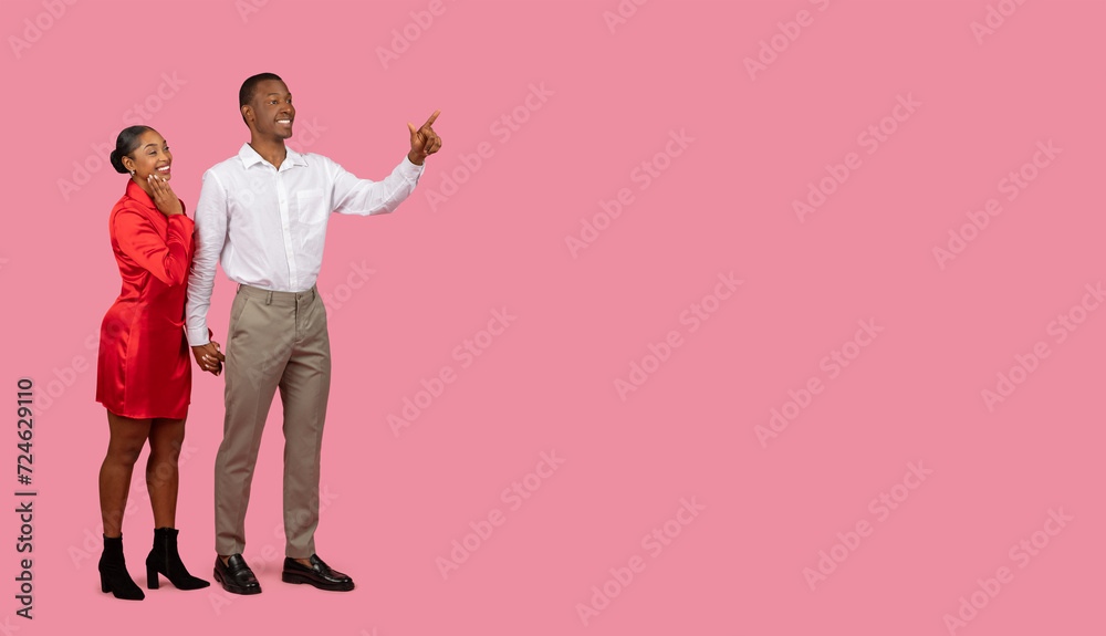 Black man pointing at free space, woman smiling in agreement Black man pointing at free space, woman smiling in agreement