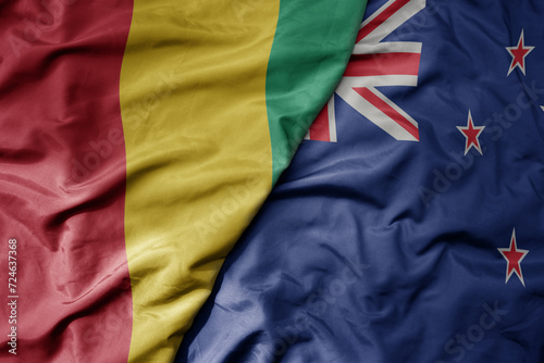 big waving national colorful flag of new zealand and national flag of guinea . © luzitanija